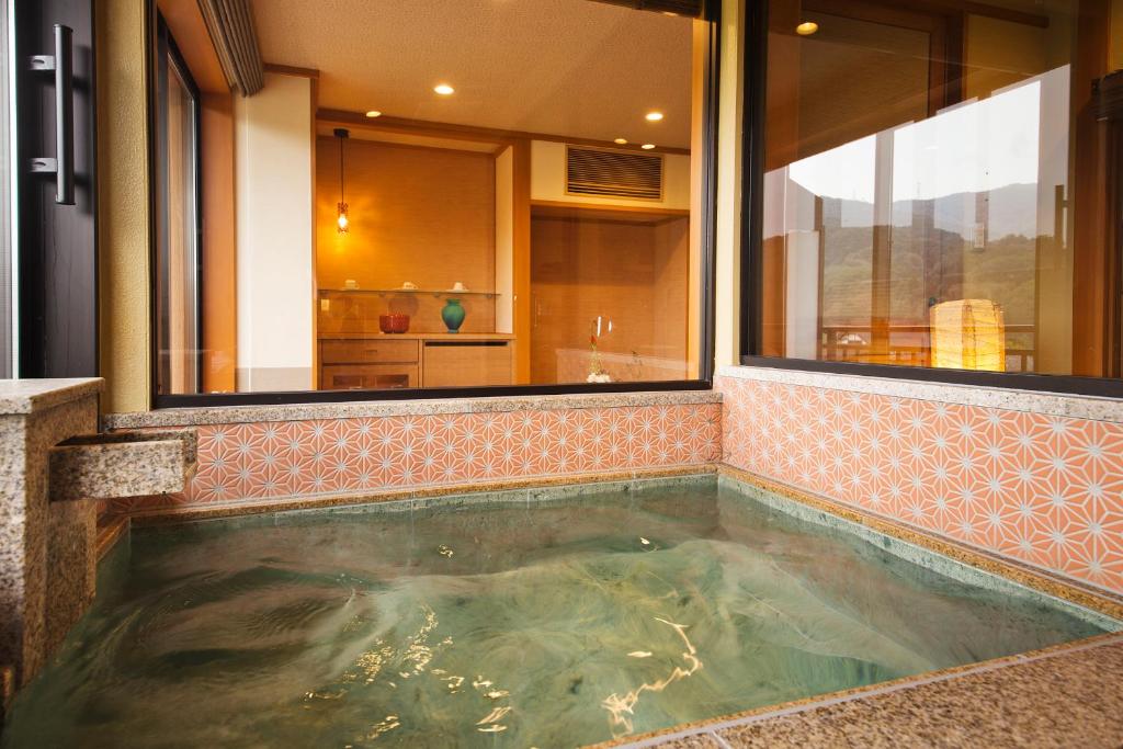 a jacuzzi tub in the middle of a bathroom at Kanazawa Hyakurakusou in Kanazawa