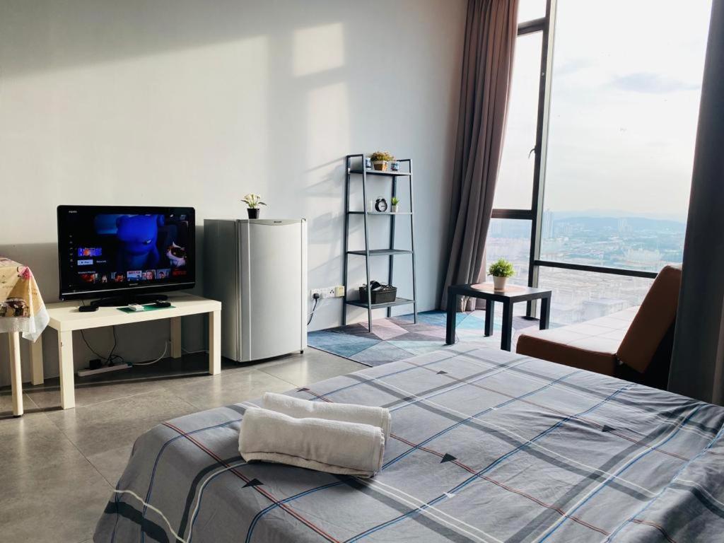 um quarto com uma cama, uma televisão e uma janela grande em Miza Empire Damansara studio free wifi netflix em Petaling Jaya