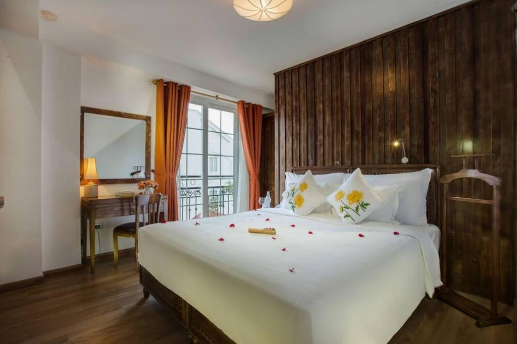 una camera con un grande letto bianco e una scrivania di Singita Classy Boutique Retreat & Travel a Hanoi