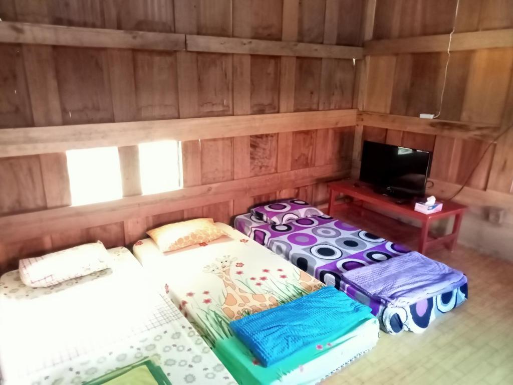 a room with two beds and a tv in it at NUANSA HOMESTAY Authentic&Hospitality in Rantepao
