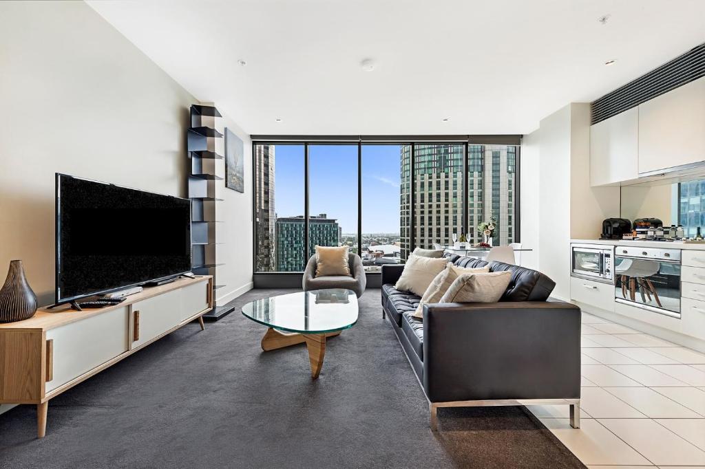 a living room with a couch and a tv at Luxury designer suite in most prestigious location in Melbourne in Melbourne