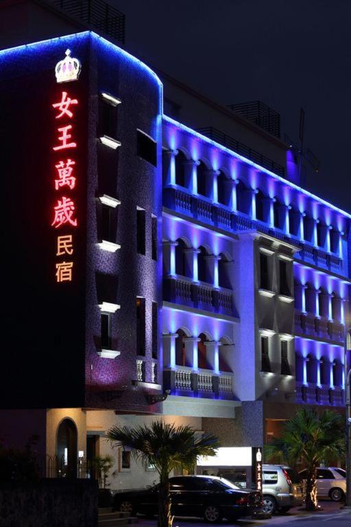 a building with a blue and red sign on it at Queen Love Homestay in Hualien City