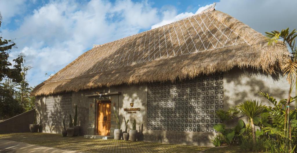 un edificio con techo de paja y puerta en Villa Amantes Bingin, en Uluwatu