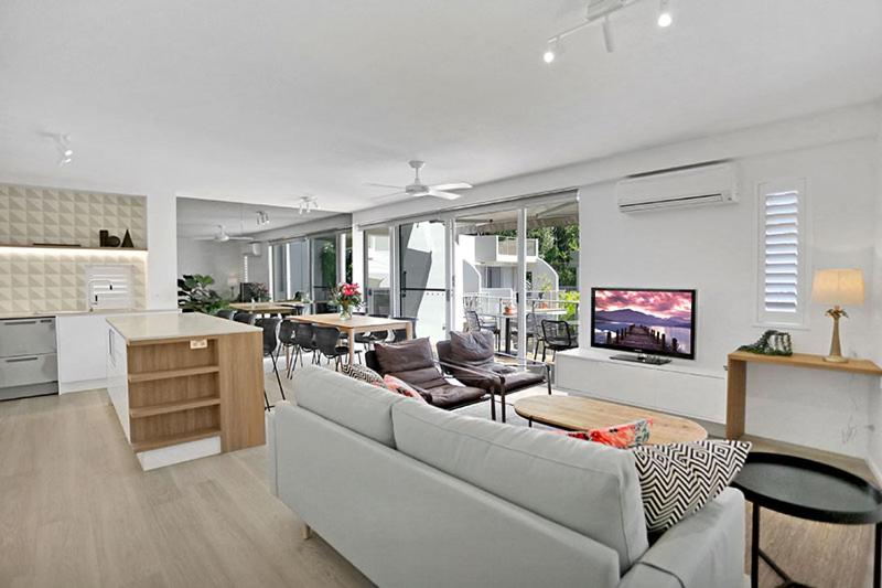 a large living room with a couch and a kitchen at The Cove Noosa - Apartment 22 in Noosa Heads