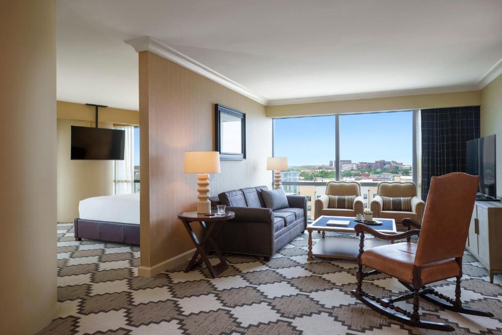 a hotel room with a bed and a living room at Omni Fort Worth Hotel in Fort Worth
