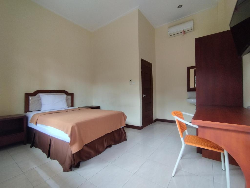 a hotel room with a bed and a piano at Adi Pelita Sari Bali in Denpasar