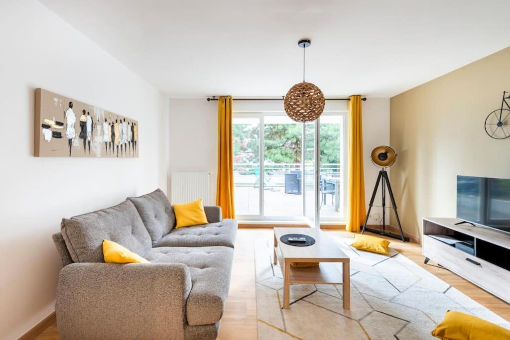 uma sala de estar com um sofá e uma mesa em Comme chez vous em Estrasburgo