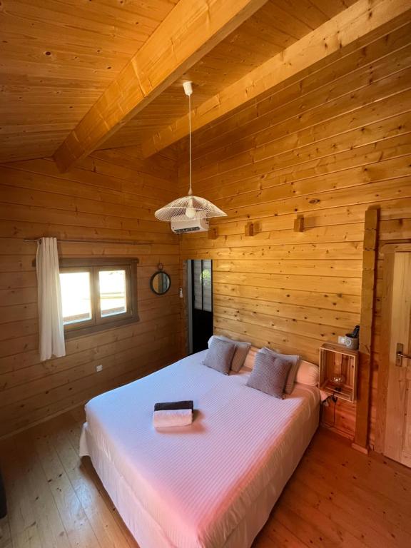 une chambre avec un grand lit dans une pièce en bois dans l'établissement U Mo Sognu, à Murzo