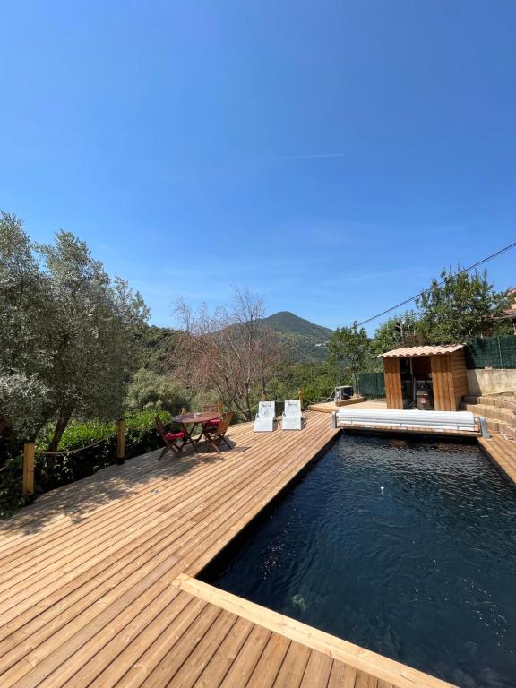 a wooden deck with a pool and a table and chairs at U Mo Sognu in Murzo