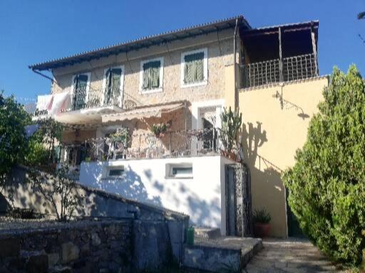 ein großes Haus mit einem Zaun davor in der Unterkunft Ca' Clémentine in Sasso di Bordighera