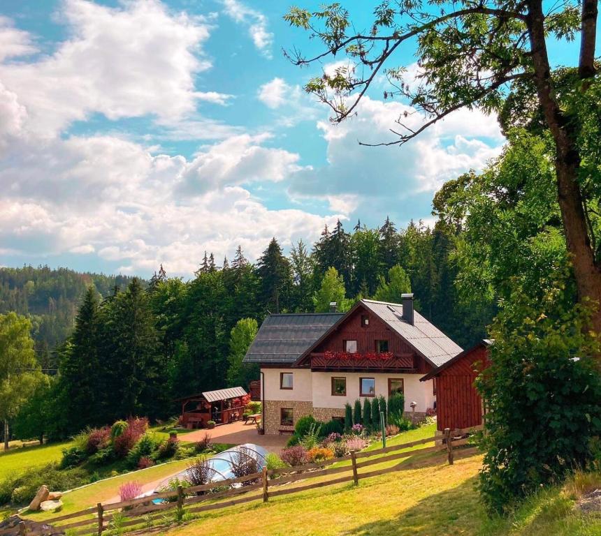 a red and white house in the middle of a field at Na Planýrce in Paseky nad Jizerou