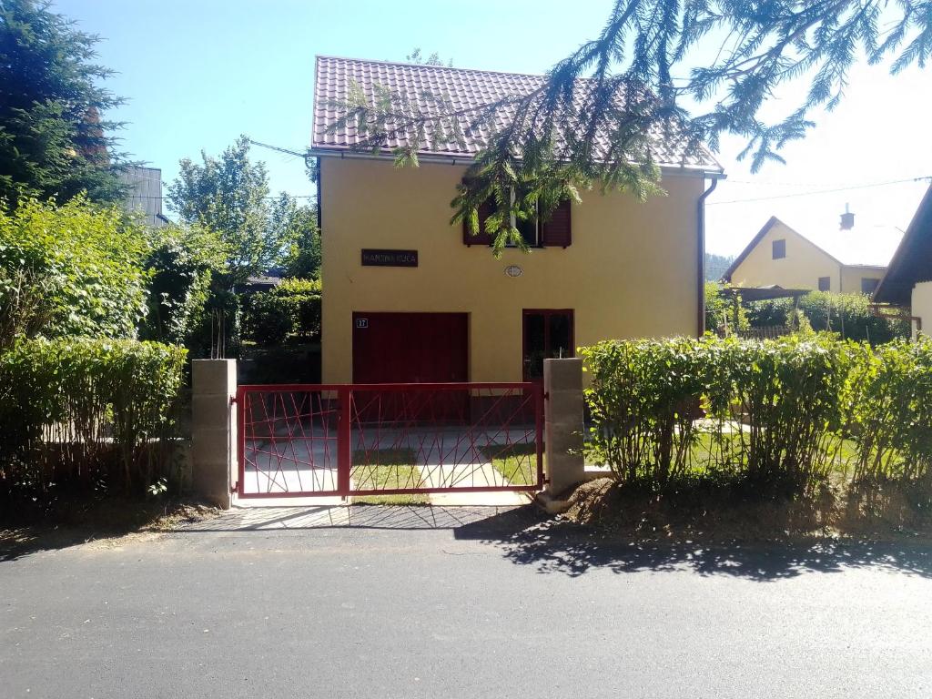 a house with a red gate in front of it at Manjina kuća in Fužine