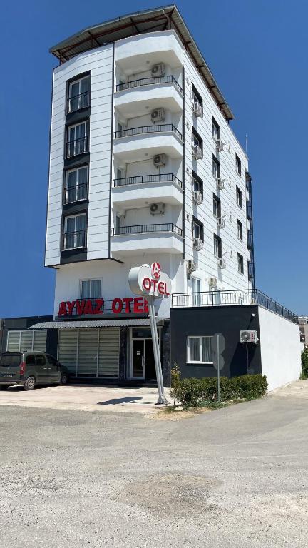 a white building with a sign in front of it at Ayvaz Otel in Torbalı