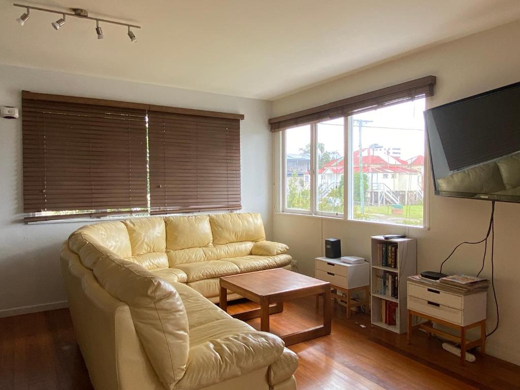 een woonkamer met een bank en een tv bij Cedar Lookout in Brisbane