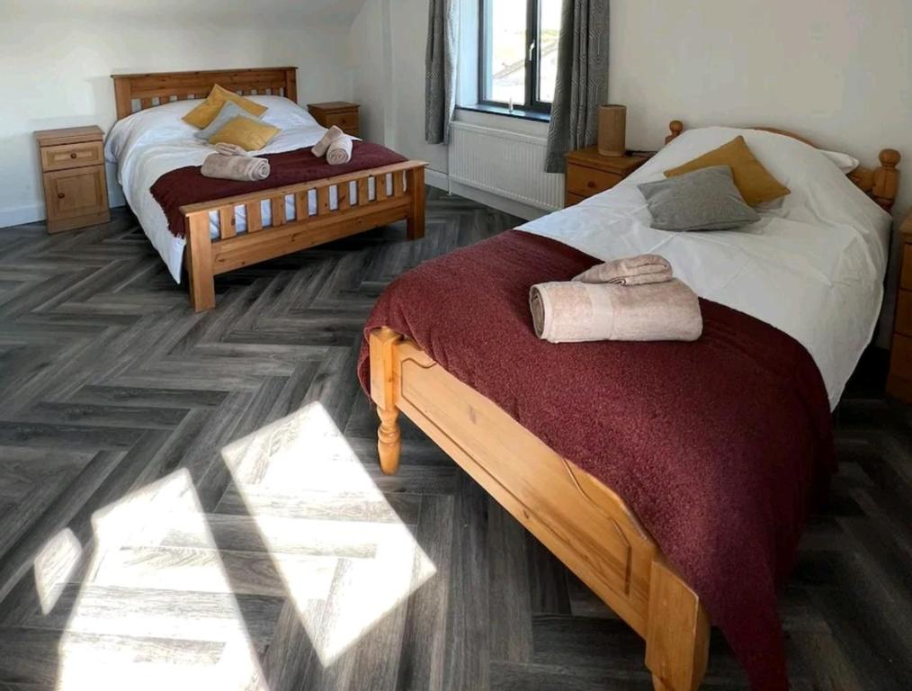 2 camas sentadas en una habitación con luz solar brillando sobre ellas en Finner House, en Ballyshannon