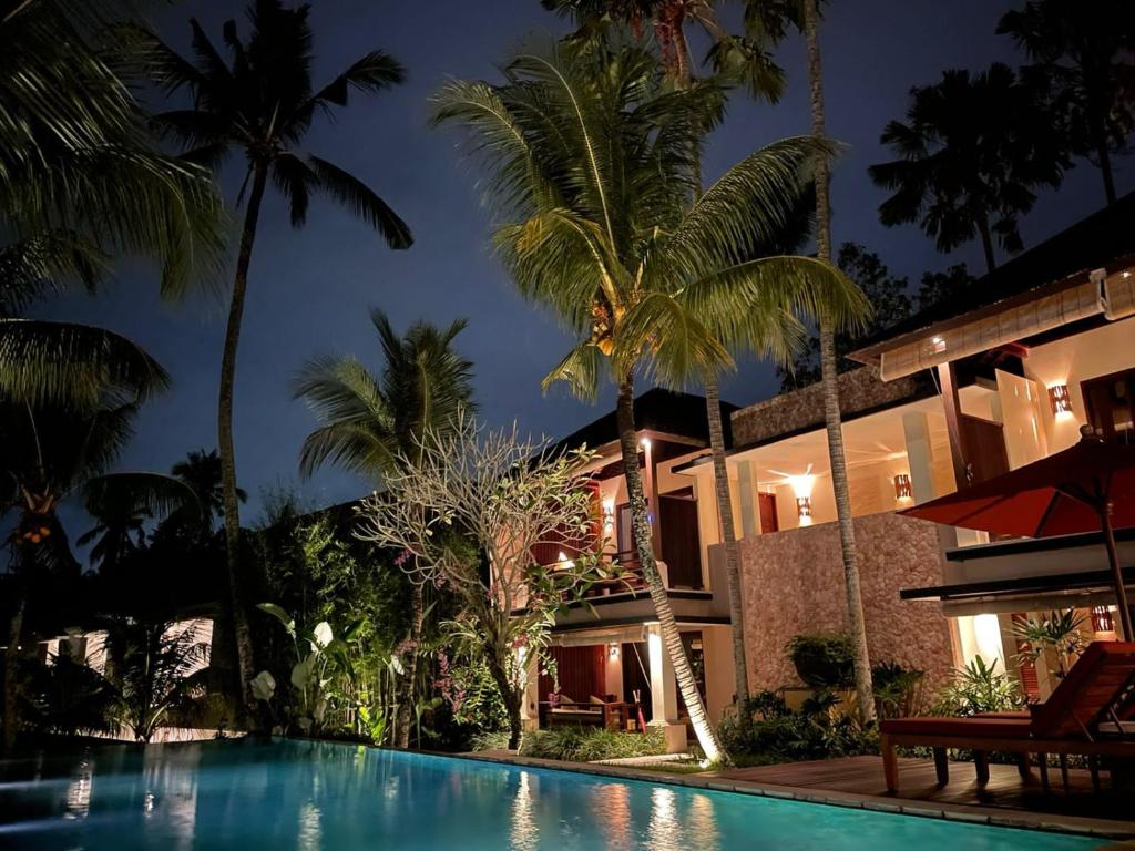 a villa with a swimming pool at night at Villa Sabandari in Ubud