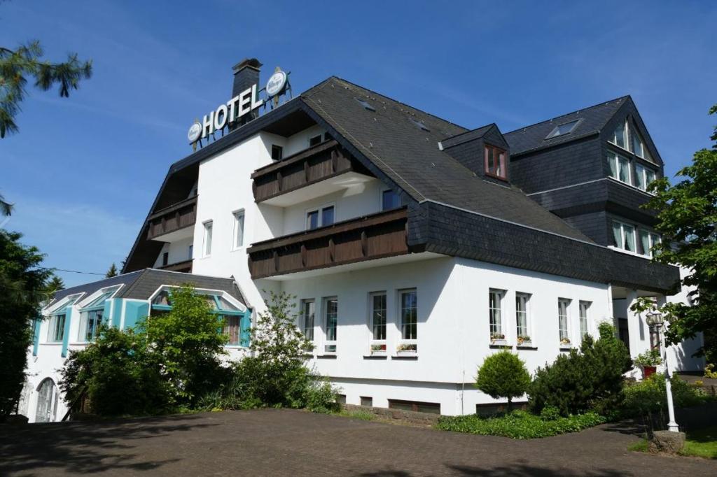 Zenner's Landhotel في Newel: مبنى ابيض كبير بسقف اسود