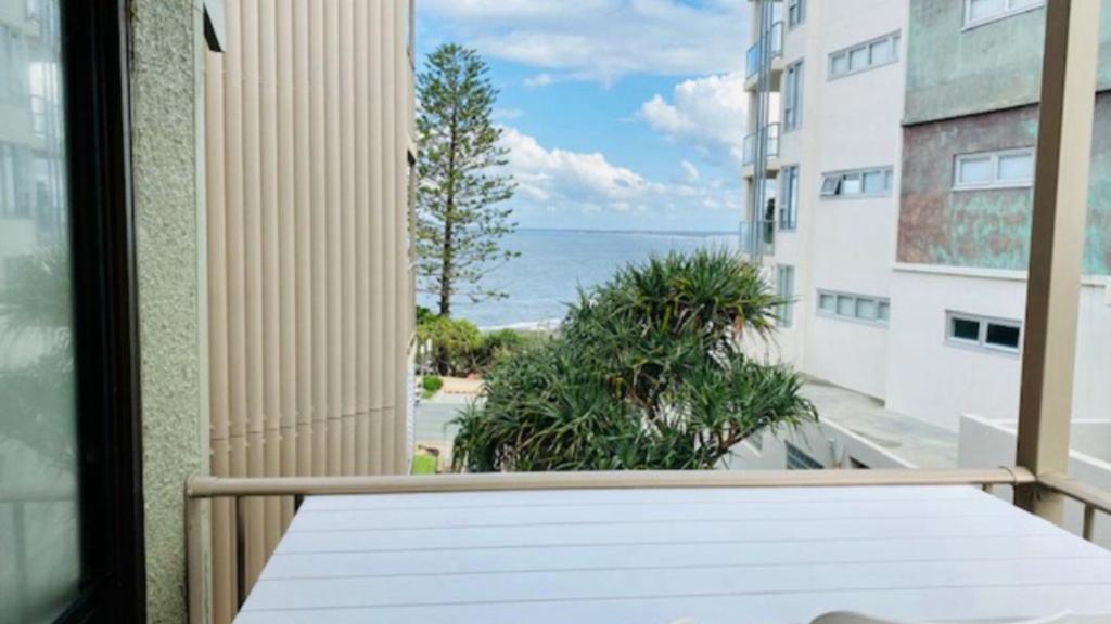 a balcony with a table and a view of the ocean at #7 Highlander, Kings Beach - Beachfront Complex in Caloundra
