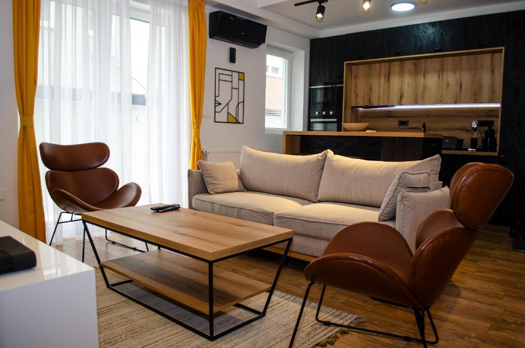 Una sala de estar con un sofá y sillas y una mesa. en Lovely 1-bedroom rental unit with free parking, en Skopje