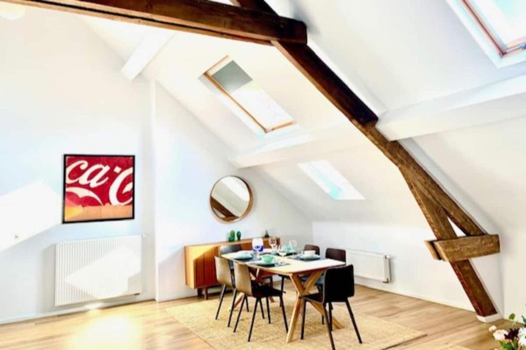 an attic dining room with a table and chairs at Sam in Antwerp in Antwerp