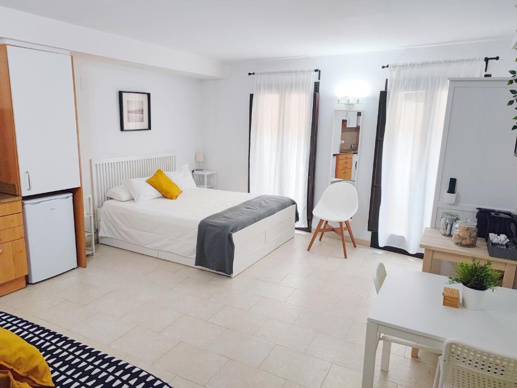 Girona La Lleona في جيرونا: غرفة نوم بسرير وطاولة وكراسي