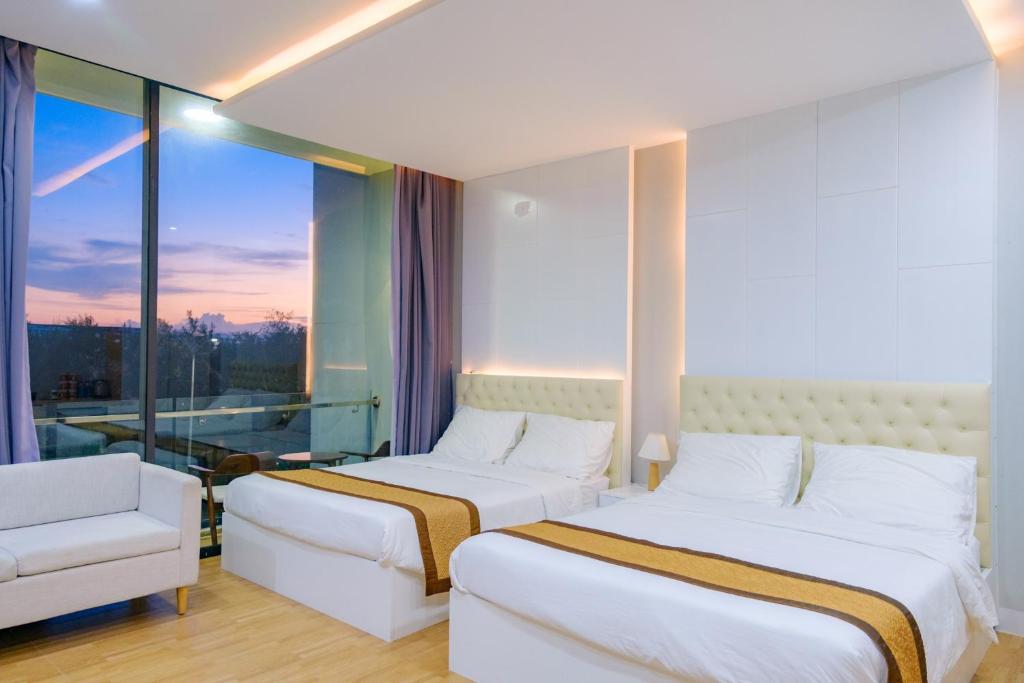 um quarto de hotel com duas camas e uma janela em Khách sạn Minh Long em Tuy Hoa