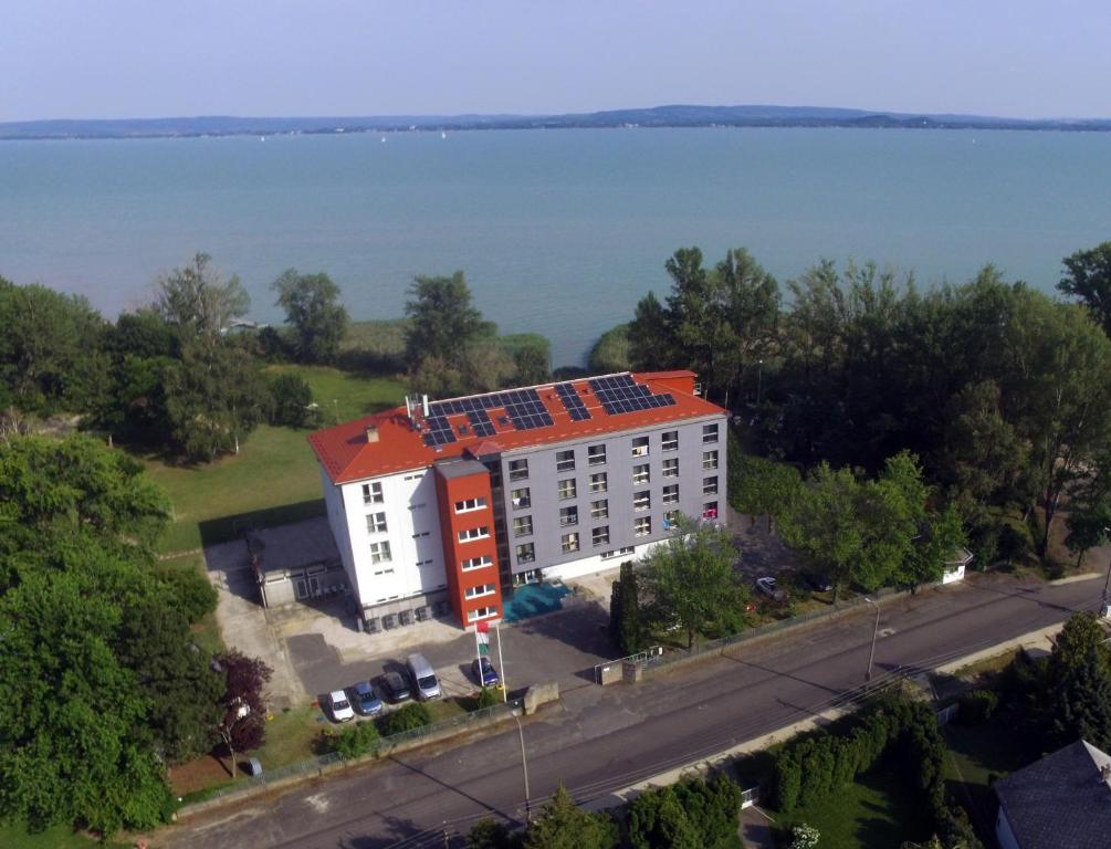 an aerial view of a building with solar panels on the roof at Beach Szálló Révfülöp in Révfülöp
