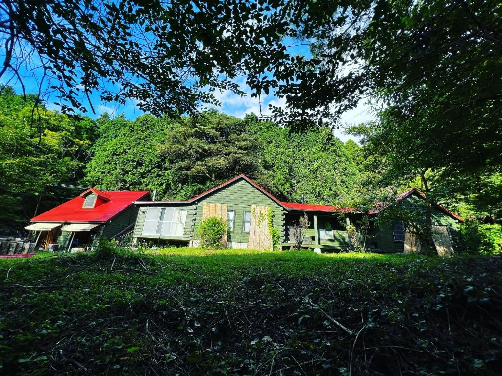a house with a red roof in the grass at 帳 -TOBARI- in Dazaifu