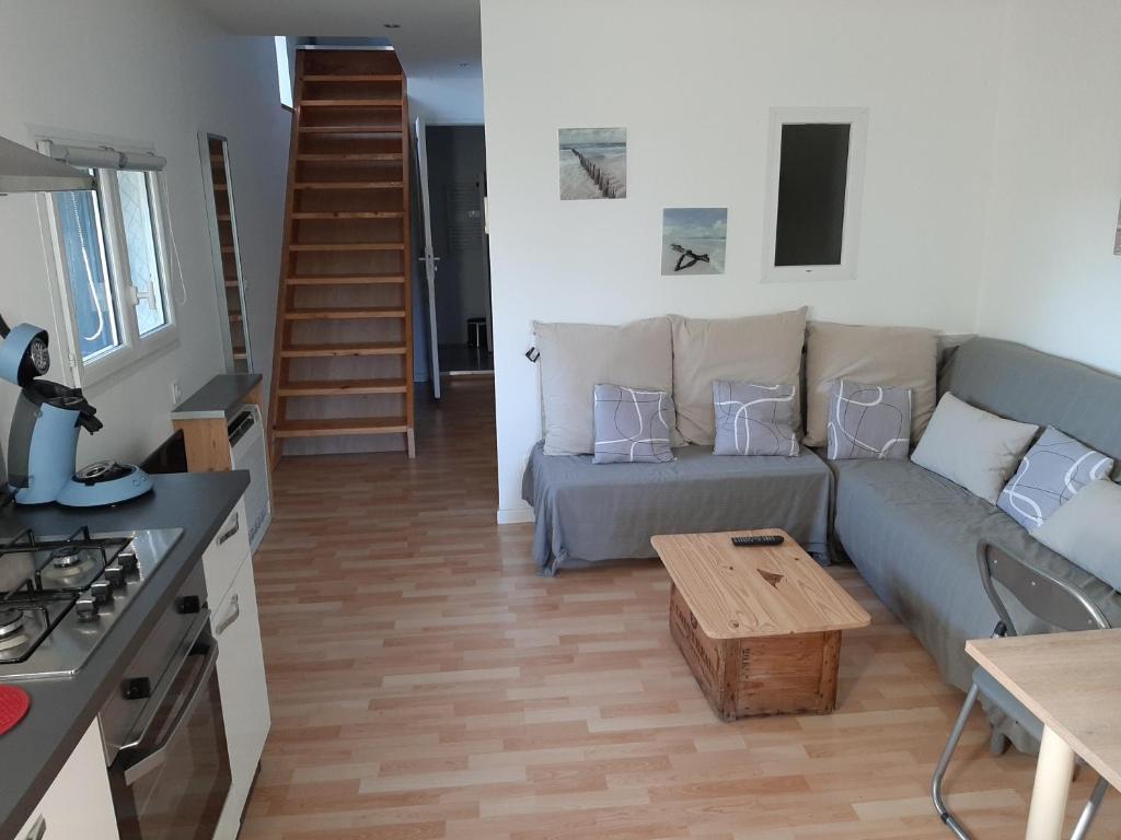 ein Wohnzimmer mit einem Sofa und einem Tisch in der Unterkunft LOCATION APPART 45 M² - 2 CH AVEC JARDIN PRIVATIF in Gailhan