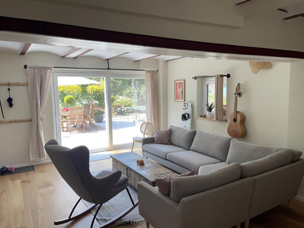 a living room with a couch and a table and a guitar at Ferienwohnung Haus am Uckersee in Prenzlau