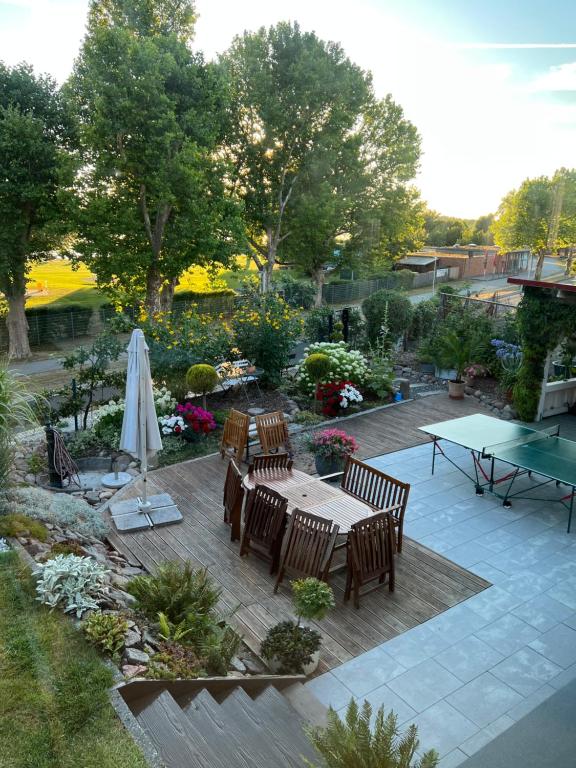 a patio with a table and chairs and a umbrella at Ferienwohnung Haus am Uckersee in Prenzlau