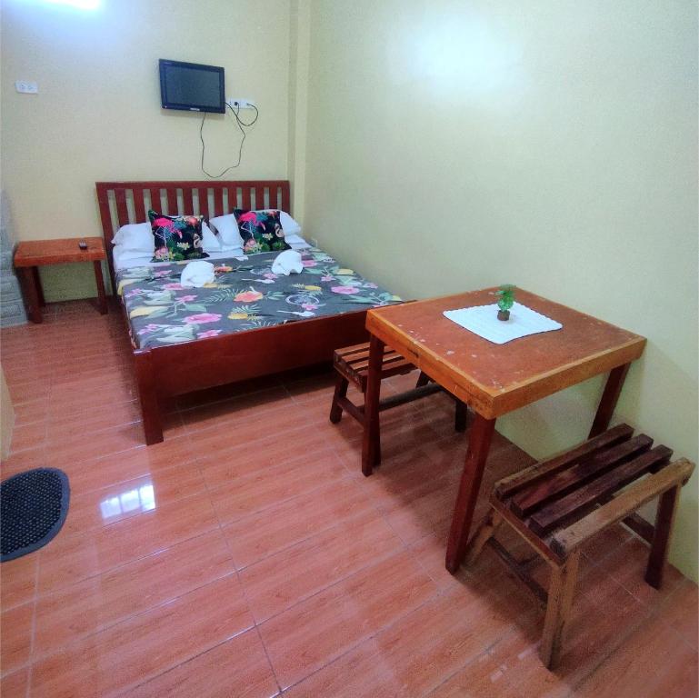 a small room with a bed and a table at Pamujo Hostel in Baclayon