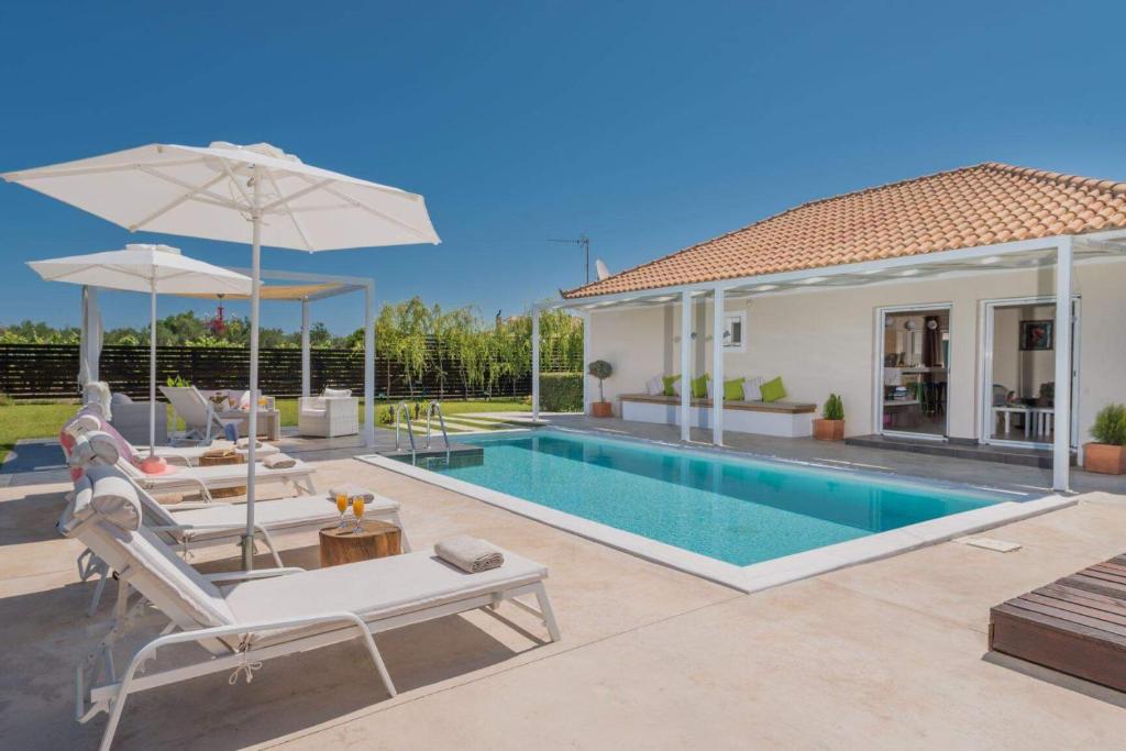 a villa with a swimming pool and a house at Madini Luxury villa with private heated pool in Vanáton