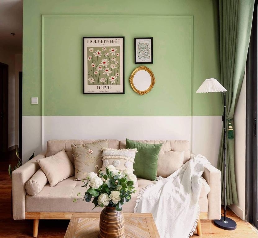 a living room with a couch and a vase of flowers at Capsule Vinhomes Ocean Park in Hanoi