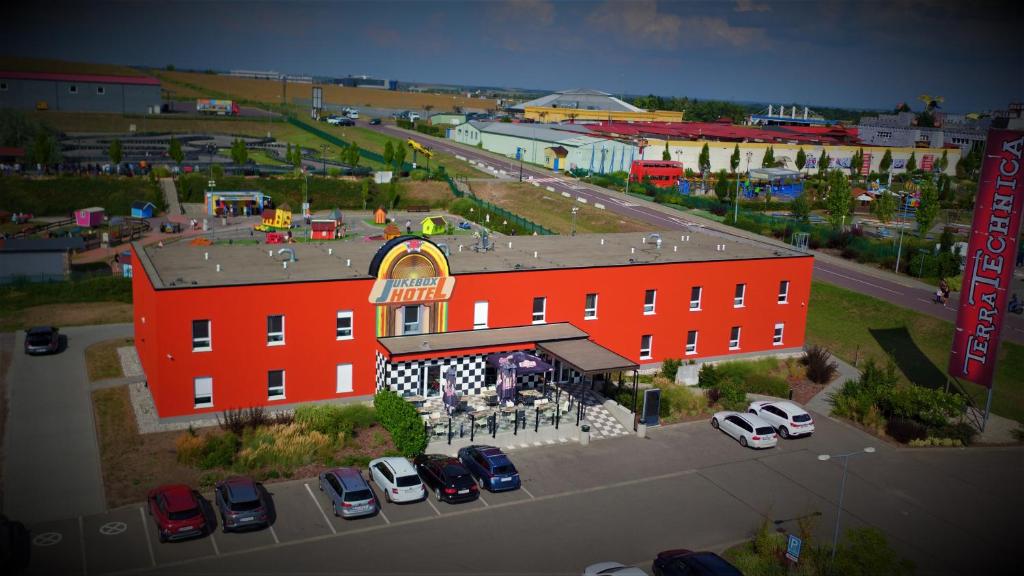 um grande edifício vermelho com carros estacionados num parque de estacionamento em Jukebox Hotel em Znojmo