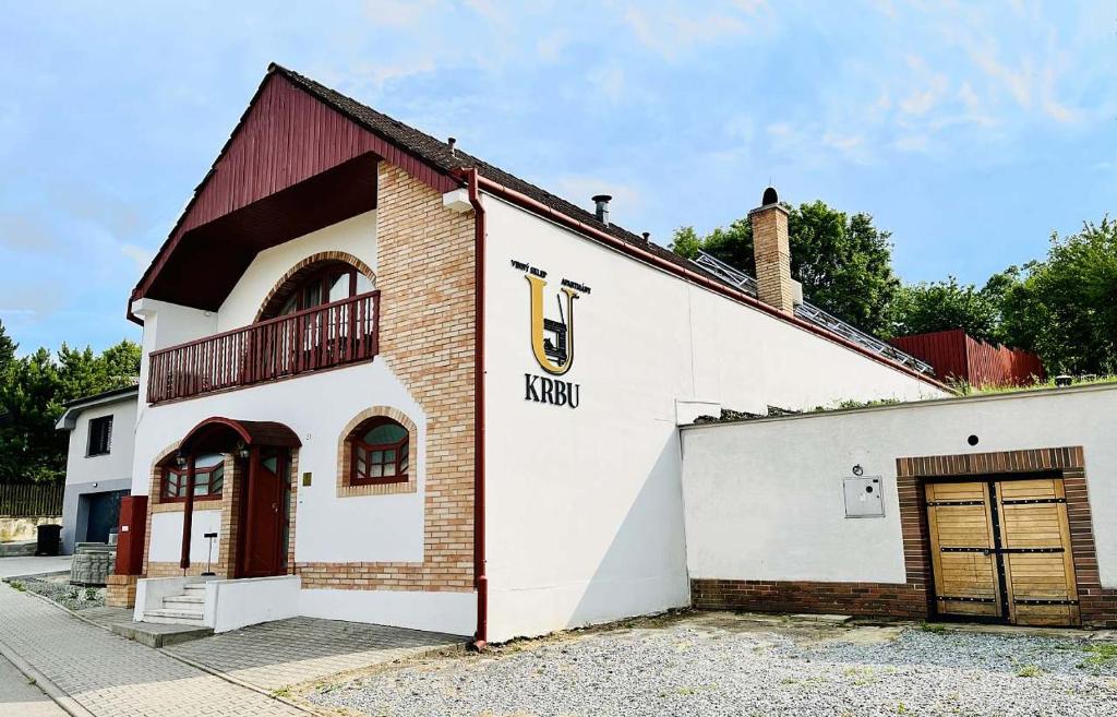 un bâtiment blanc avec un toit rouge et un garage dans l'établissement Apartmány U Krbu, à Hustopeče