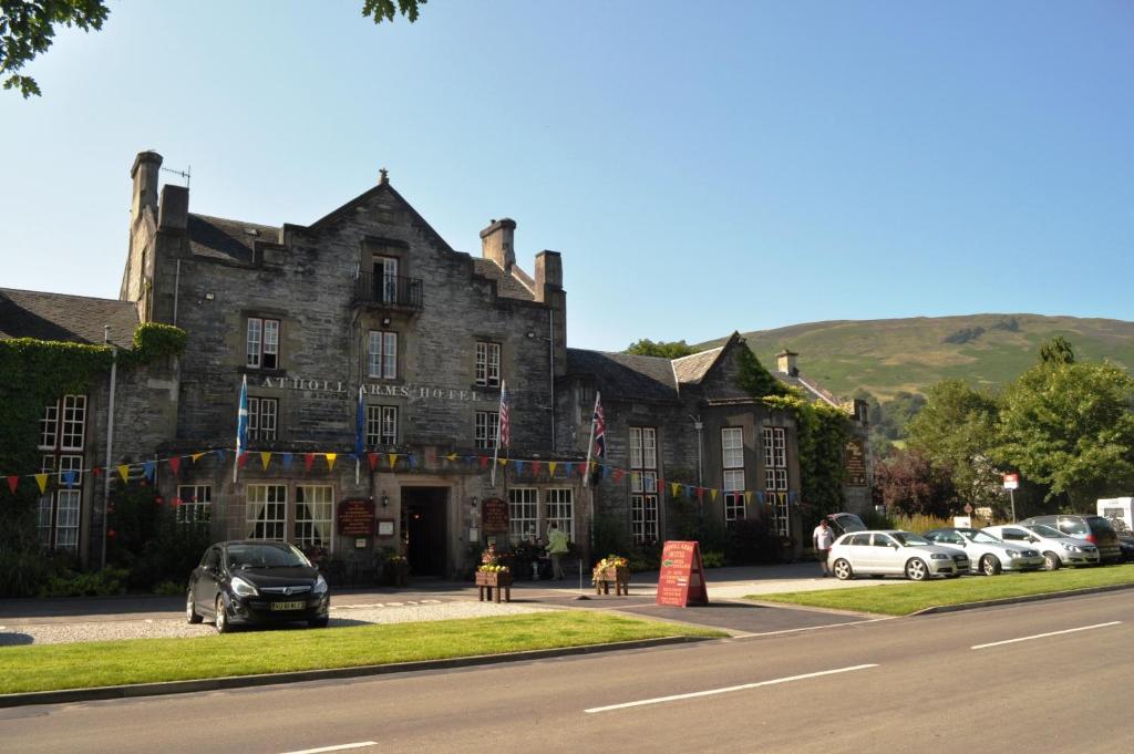 a large stone building with cars parked in front of it at Atholl Arms in Blair Atholl