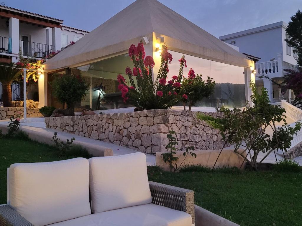 a white couch sitting in front of a building at Hotel Rural Can Maries in Puerto de San Miguel