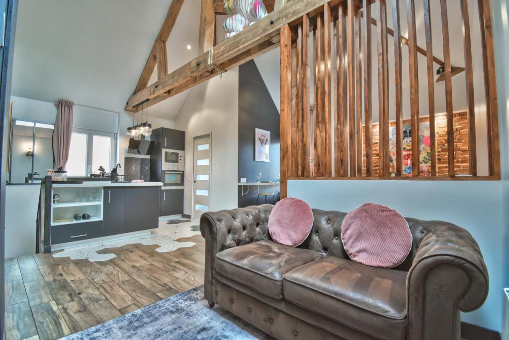 uma sala de estar com um sofá de couro e uma cozinha em * Le LoFt Des MysTèrEs * em Maintenon