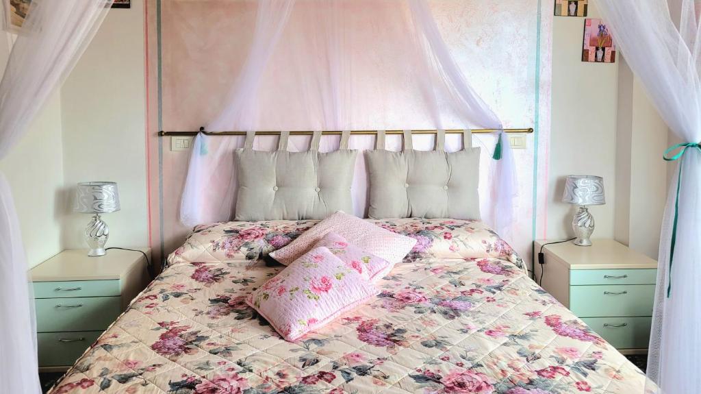 - une chambre avec un lit à baldaquin rose dans l'établissement Camera La Margherita, à San Quirico dʼOrcia