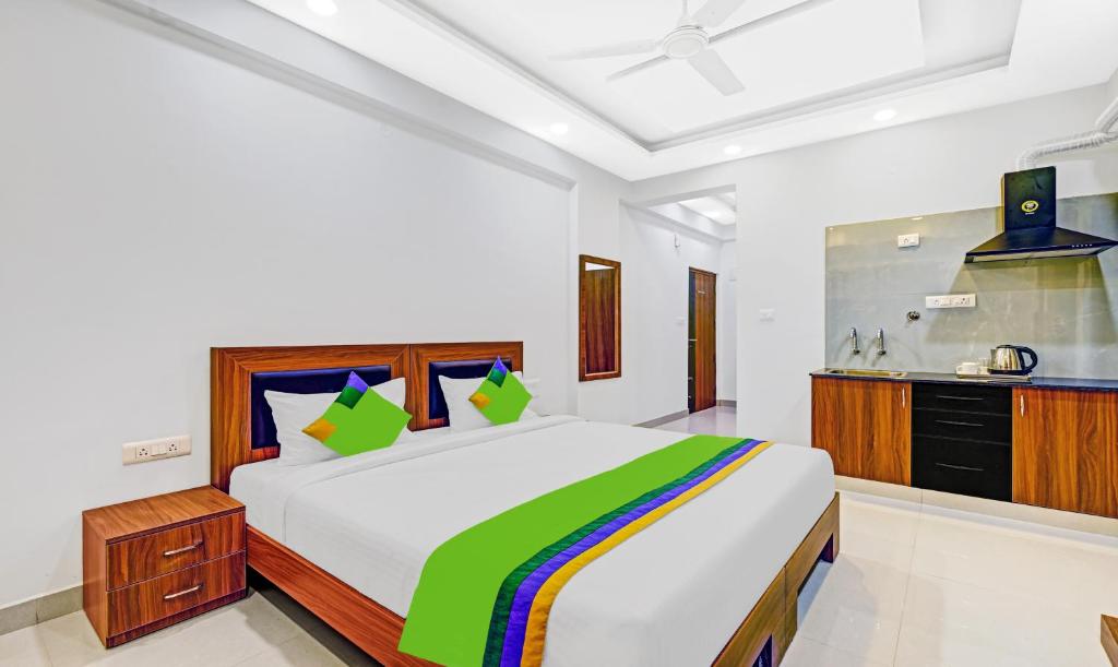 a bedroom with a large bed and a kitchen at Treebo Trend Worldtree Manyata Thanisandra in Bangalore