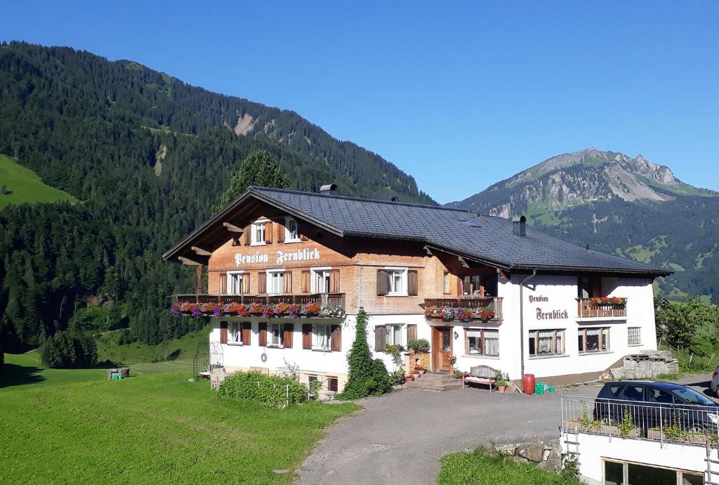 ein großes Gebäude inmitten eines Berges in der Unterkunft Fernblick Frühstückspension in Schoppernau