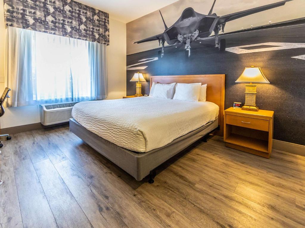 una habitación de hotel con una cama con un plano en la pared en Comfort Inn Hanford Lemoore, en Hanford