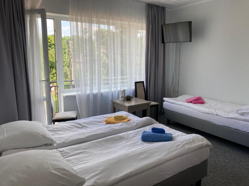 a hotel room with two beds and a window at Villa Bartosz in Międzywodzie