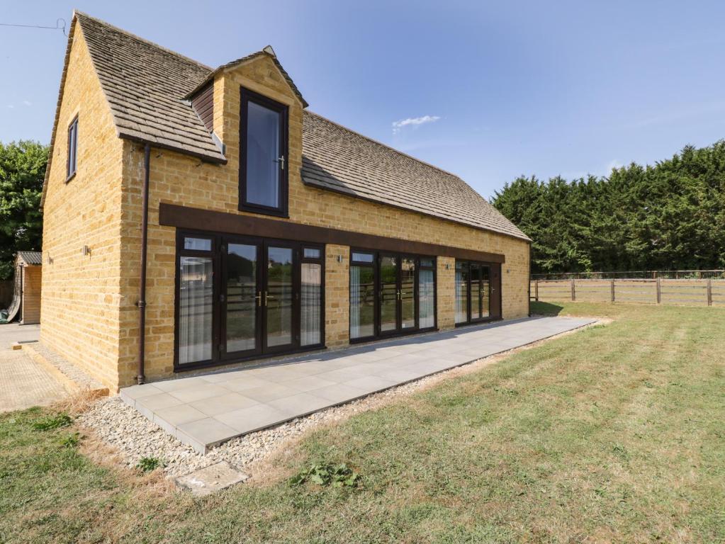 a brick house with large windows in a field at Petals Patch in Cheltenham
