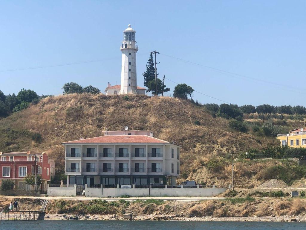 a lighthouse on top of a hill with a building at Choras Butik Otel in Şarköy