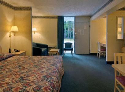 a hotel room with a bed and a living room at Howard Johnson by Wyndham Commerce GA in Commerce