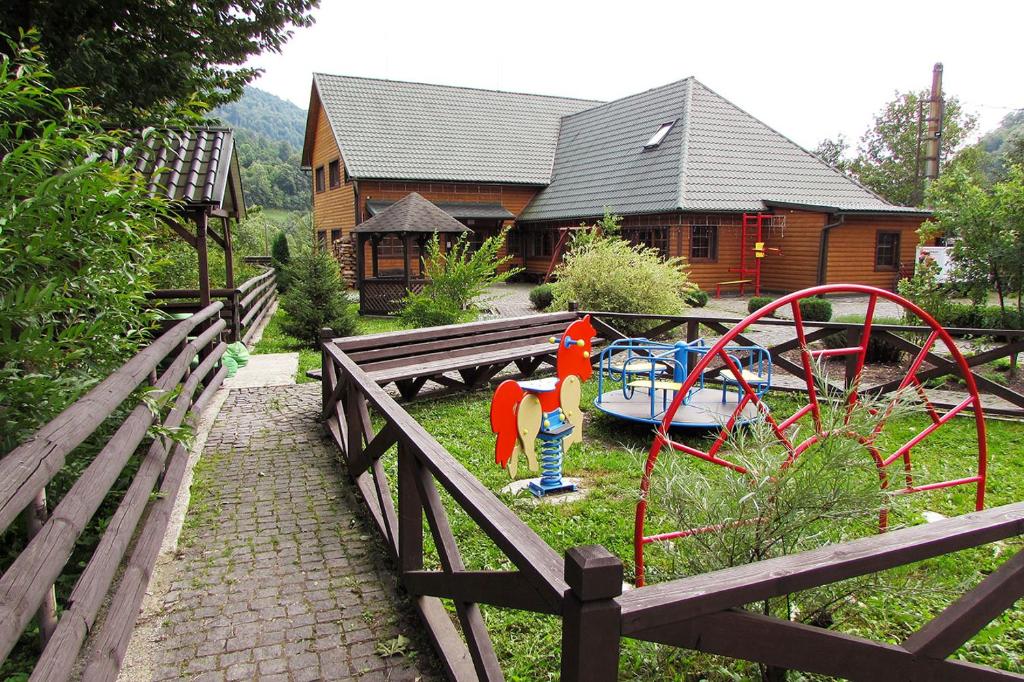 a playground in a yard with a house at Шале На бе́резі in Kvasy