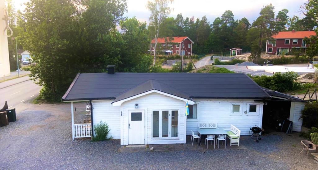 a small white shed with a black roof at House. 80m2, near Lake, with car charge. in Sommarbo