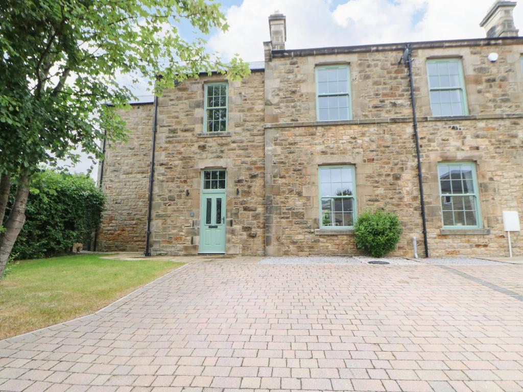 an old brick building with a blue door at 1 Claire House Way in Barnard Castle